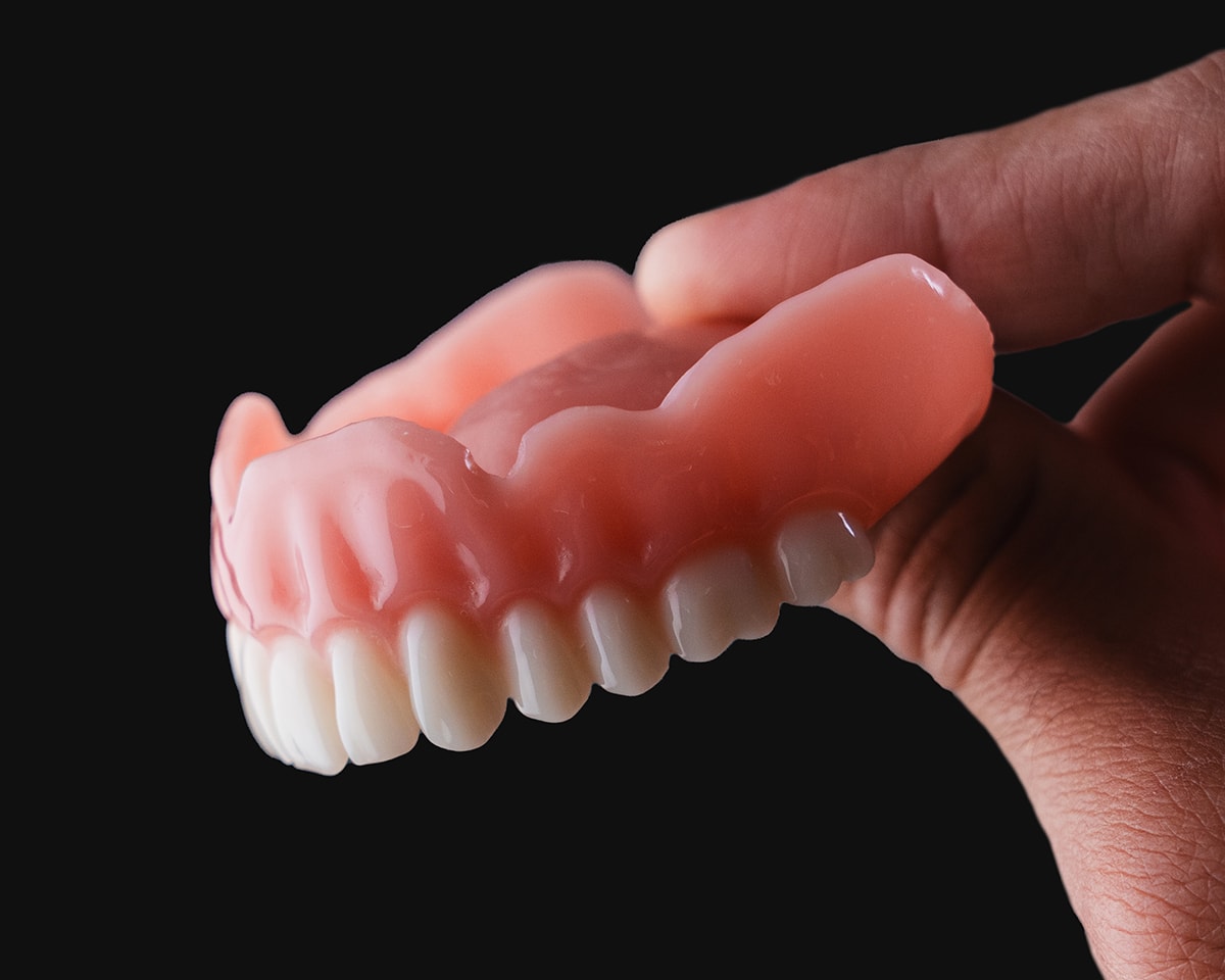 A hand holding a Flexcera upper denture