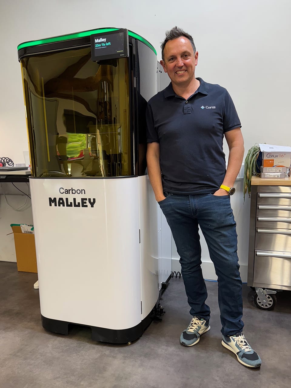 Ashley Byrne standing next to a Carbon M3 3D printer with the AO Backpack