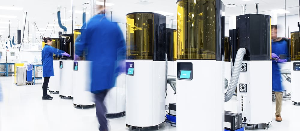 Clinician walking past a row of printers in the lab