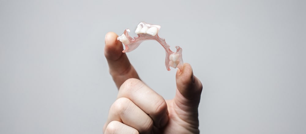 Holding a flexible denture