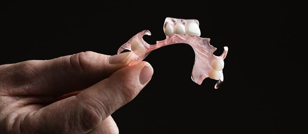 Holding a flexible denture