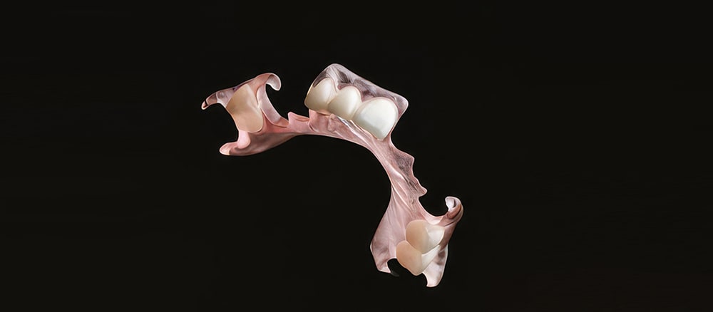 Partial, flexible denture floating on black background