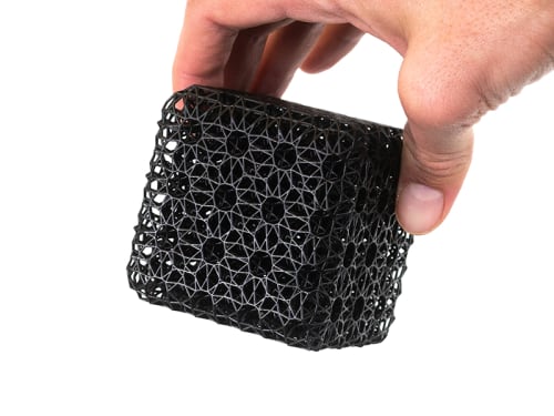 A hand holding a latticed cube made with RPU