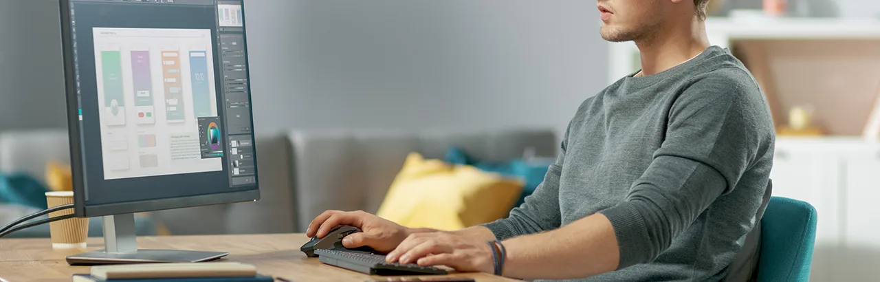 partial image of a man working on UI UX design on his desktop computer