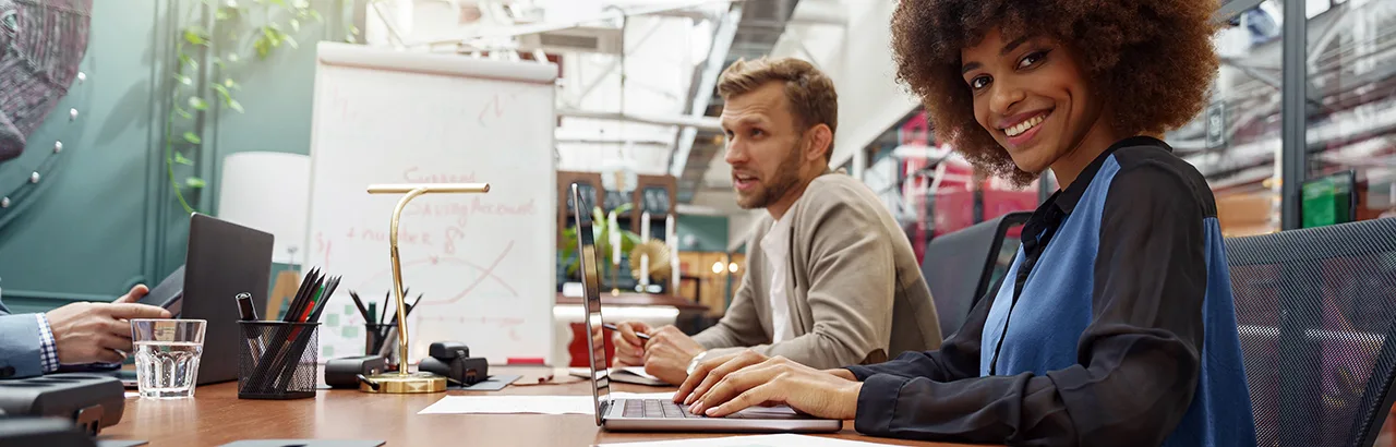 a smiling male and female interviewer in deep conversation with an applicant for a position in cybersecurity with no experience