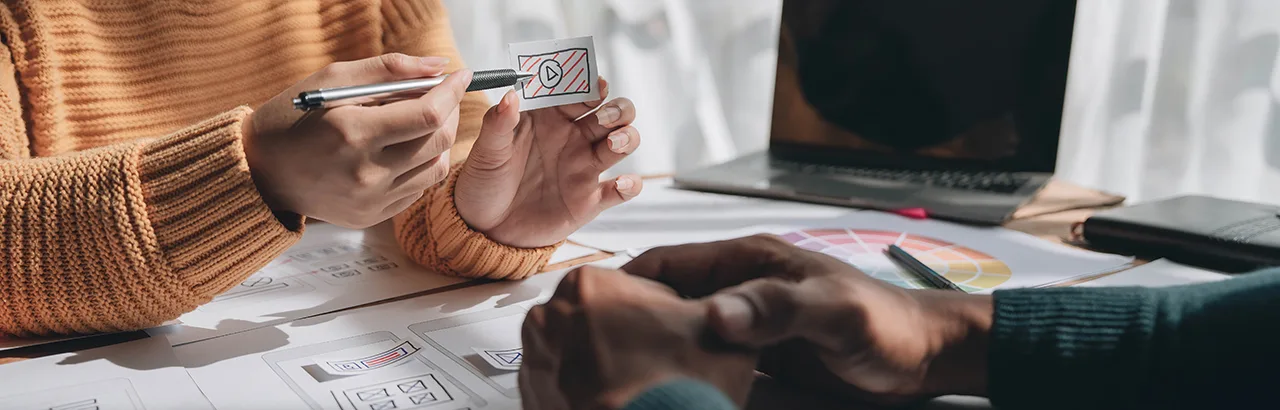 partial image of a female ui/ux designer presenting her design to a client