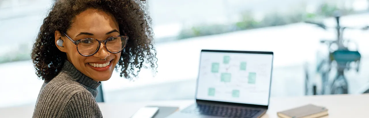 a smiling female African-American software engineer on her open laptop