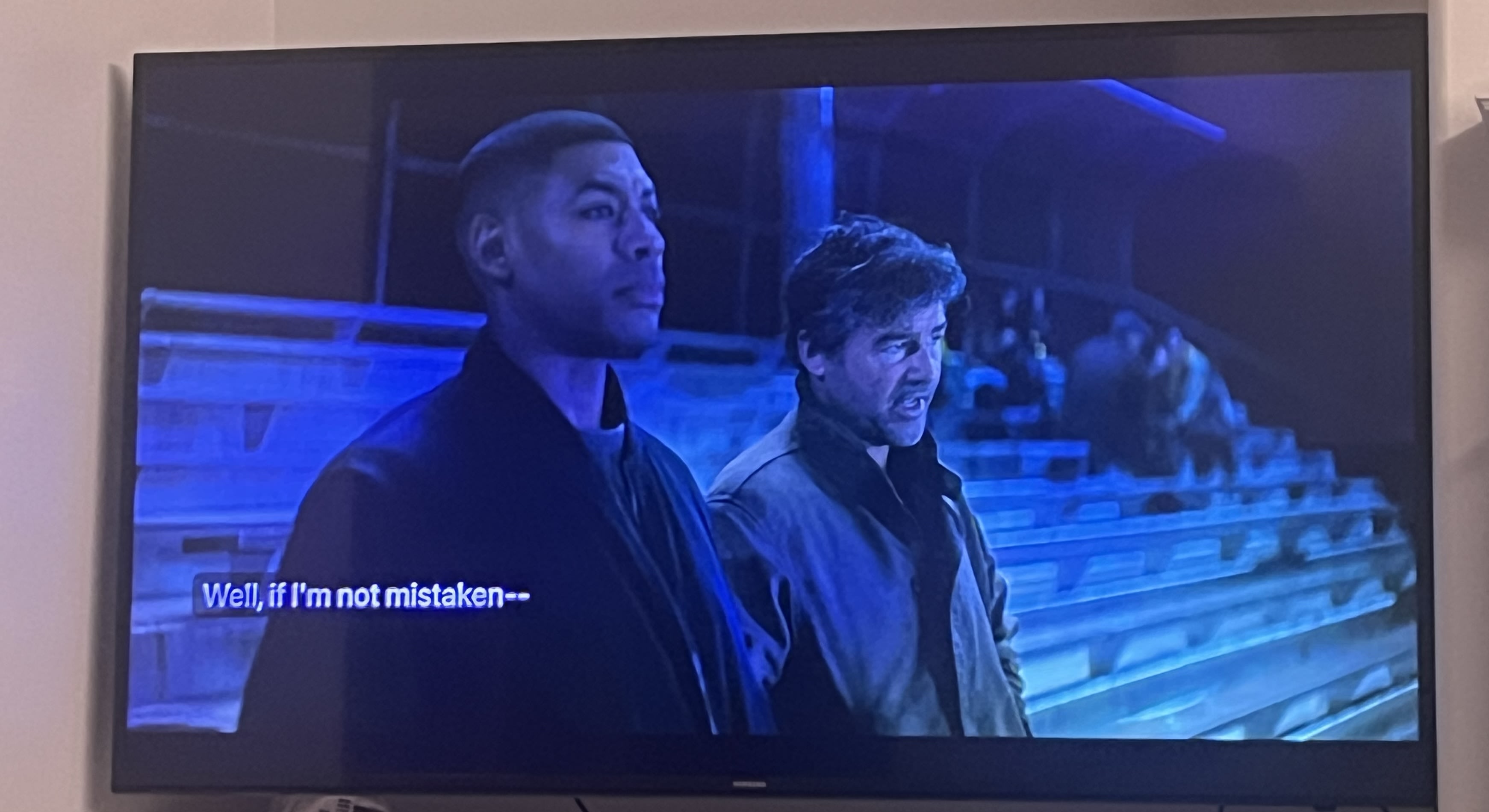 A photo of a TV playing the TV show Lanterns which shows Aaron Piere playing John Stewart and Kyle Chandler playing Hal Jordan