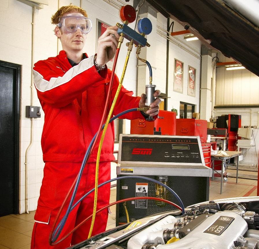 image of a technician fixing a cars air con unit