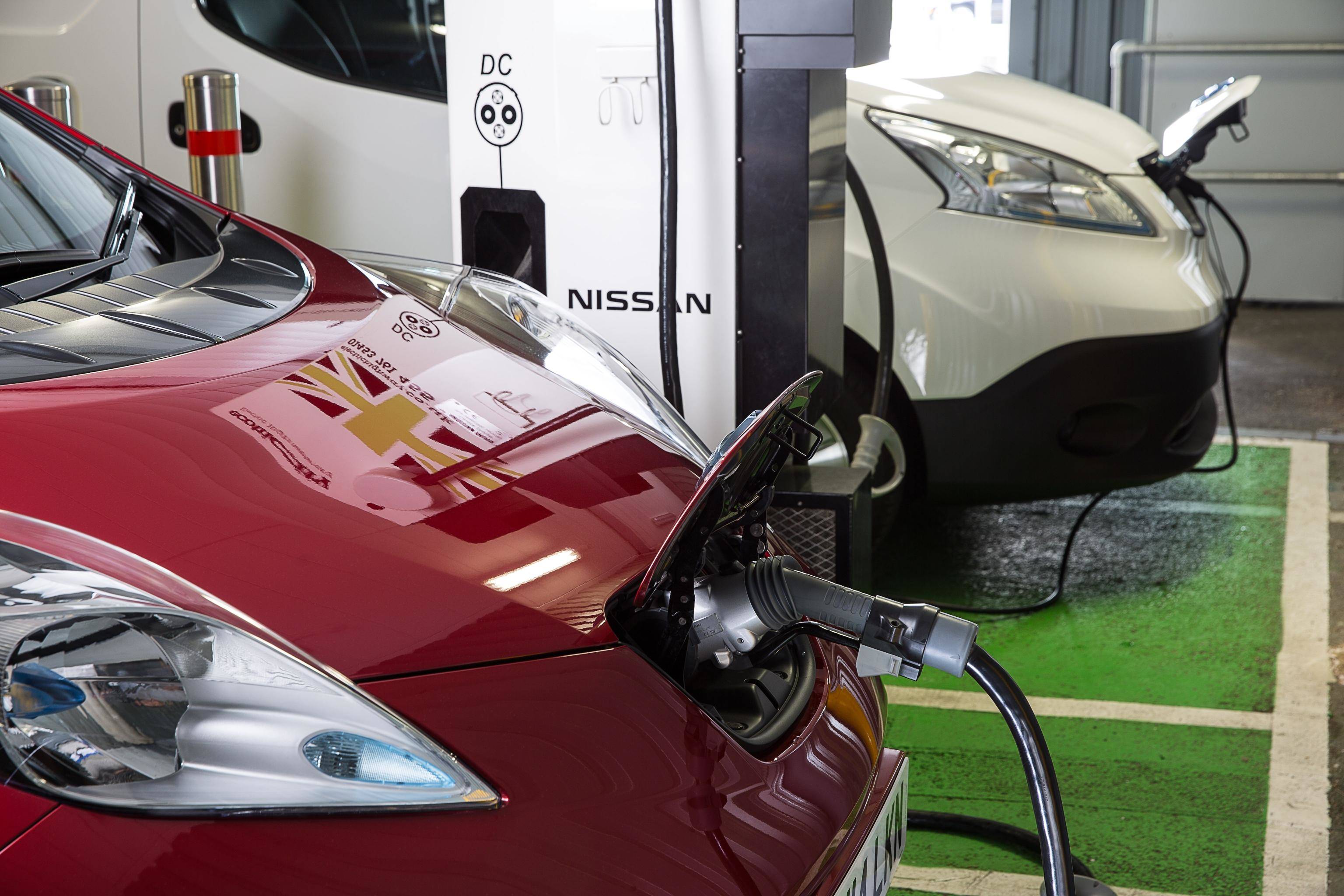 image of two nissan leaf cars plugged into charging stations