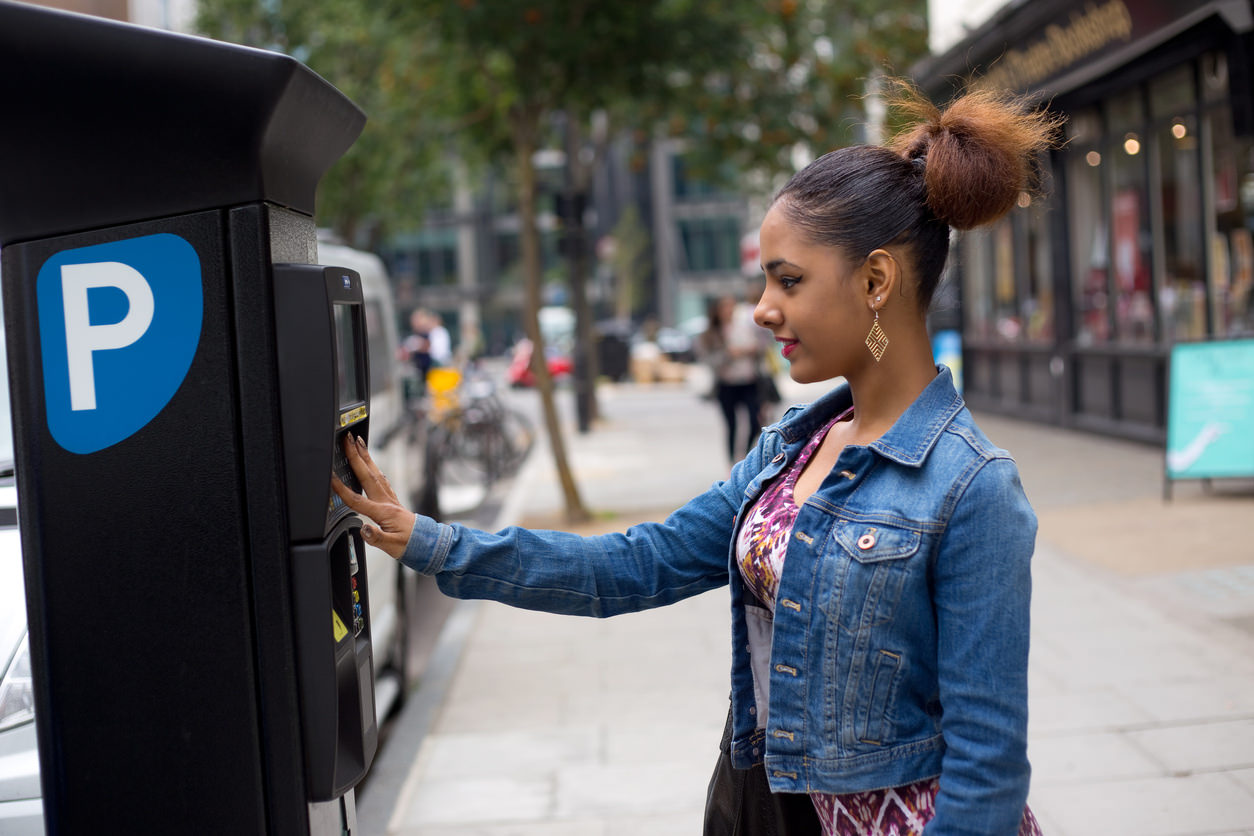 image of a person purchasing a parking ticket from a machine