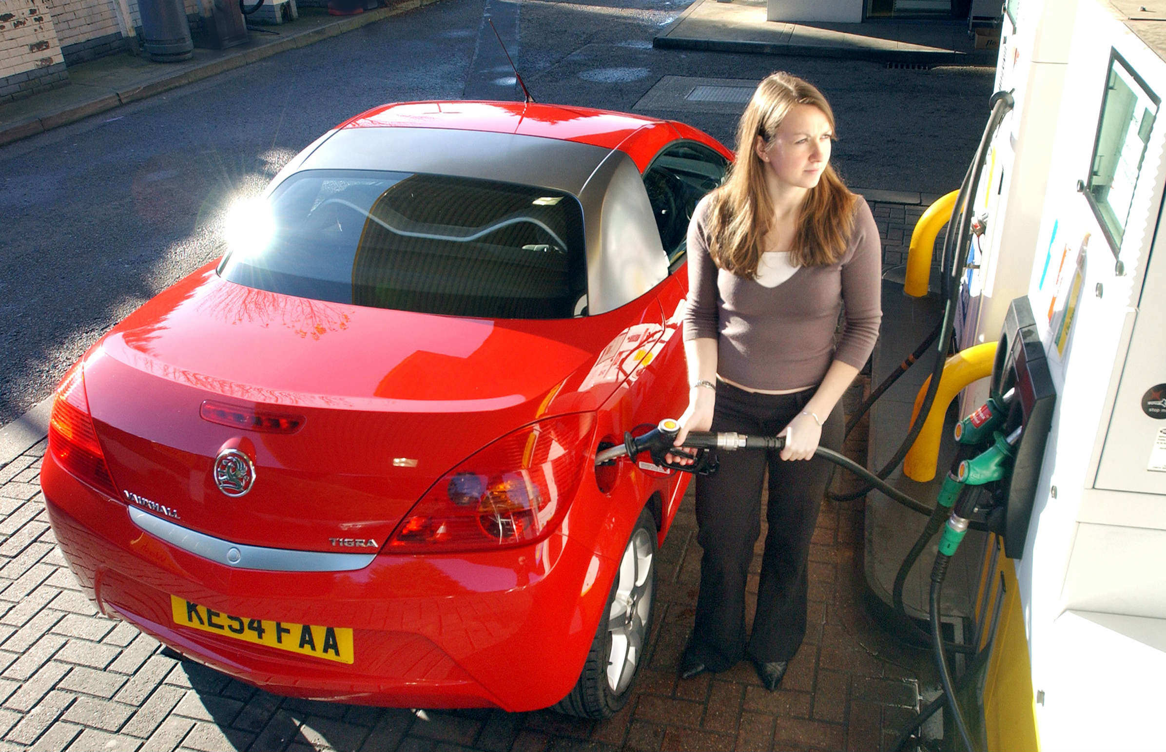 image of a person filling up their car at a petrol station