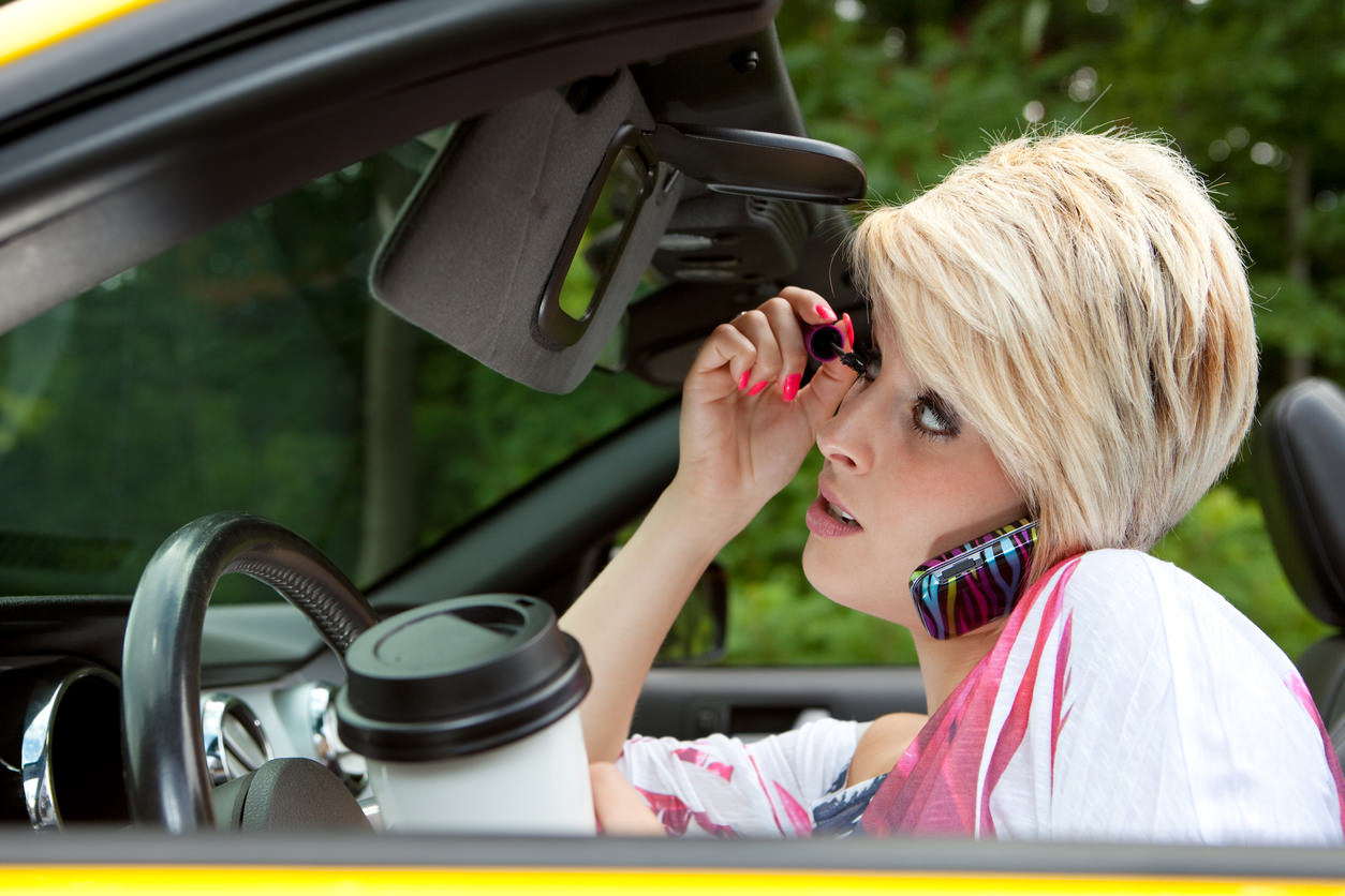 image of a person distracted from driving with makeup and phone