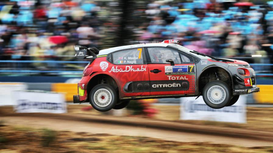 image of kris meekes rally car in mid air during a race