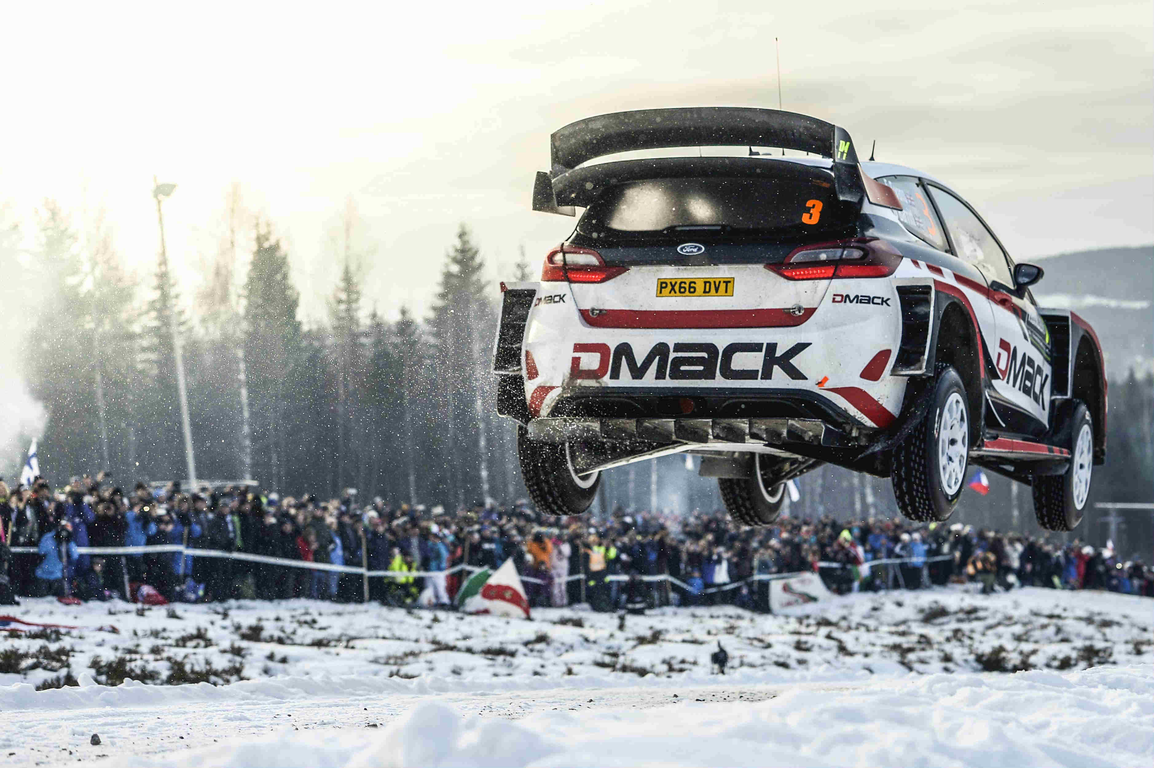 image of elfyn evans rally car in mid air during a snow race