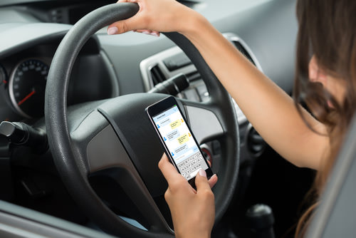 image of a person on a mobile phone whilst driving