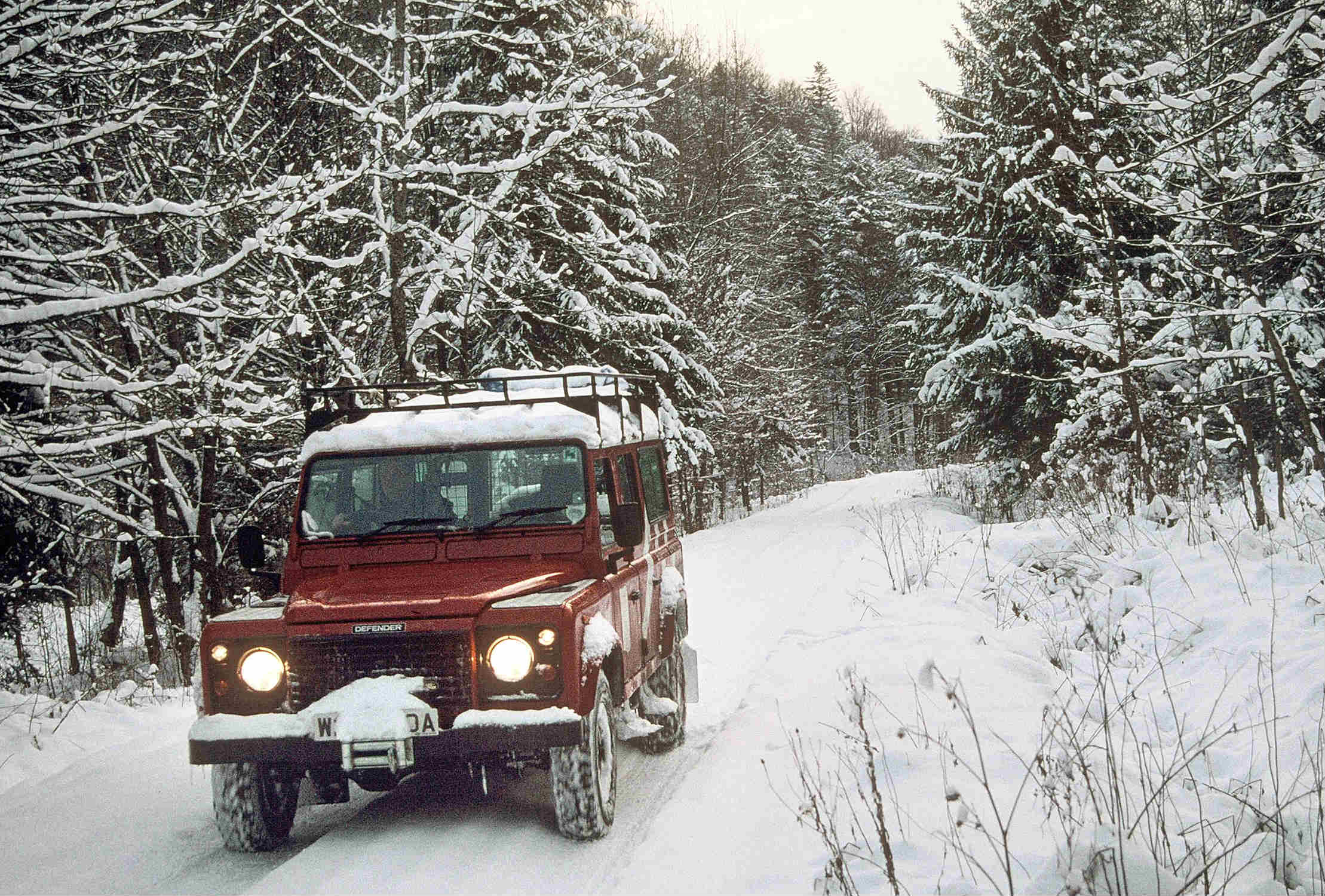 image of a vintage land rover in snow conditions