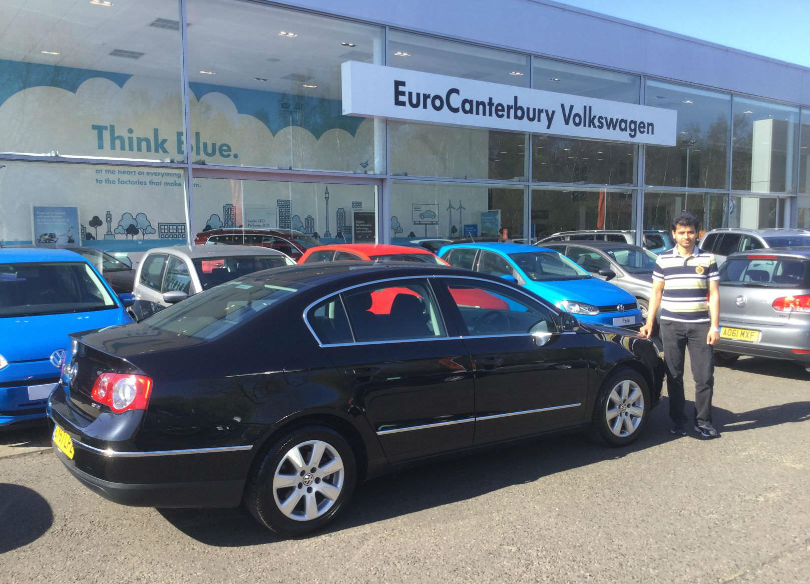 image of a black volkswagen passat parked outside a volkswagen dealership