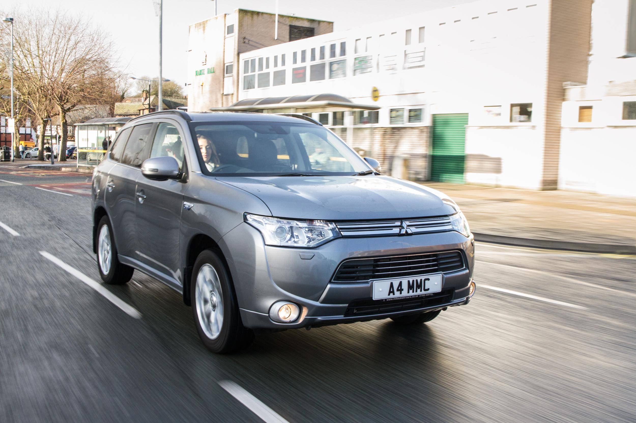 Woman Driving a Grey Hybrid SUV Mitsubishi PHEV down a road