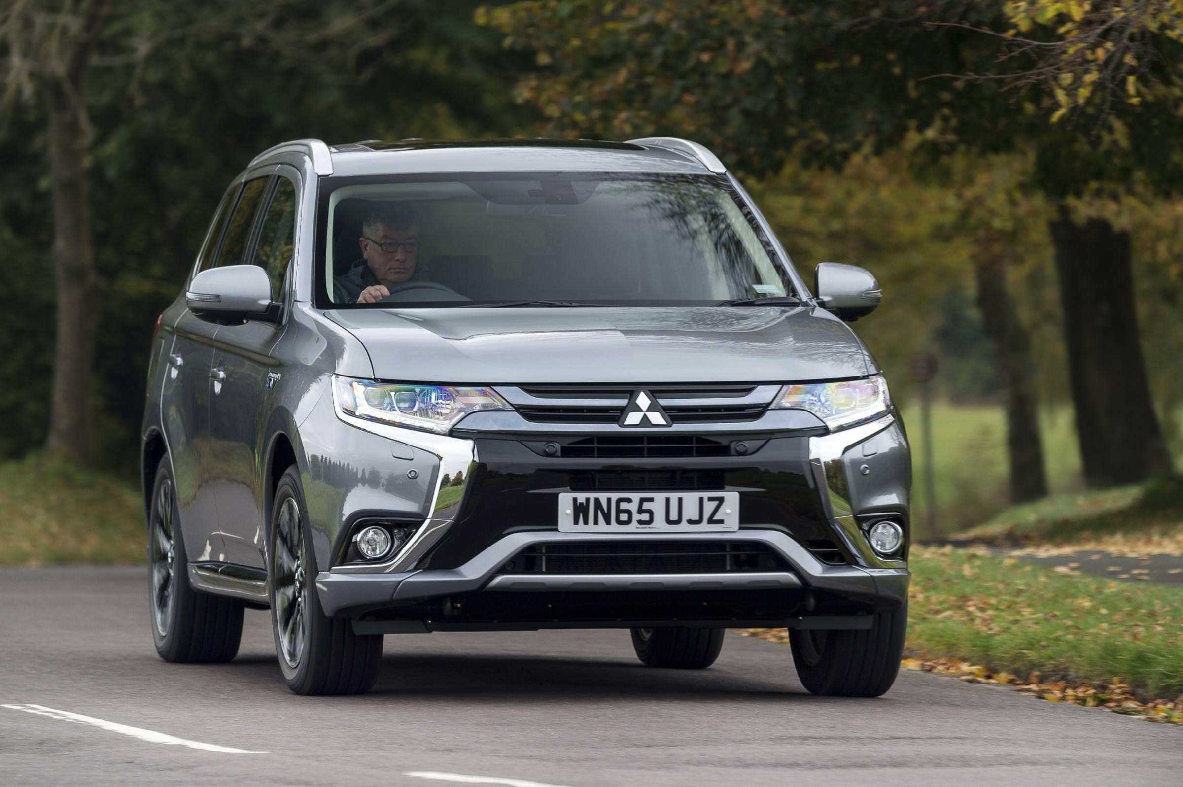 Used silver Mitsubishi driving down countryside road