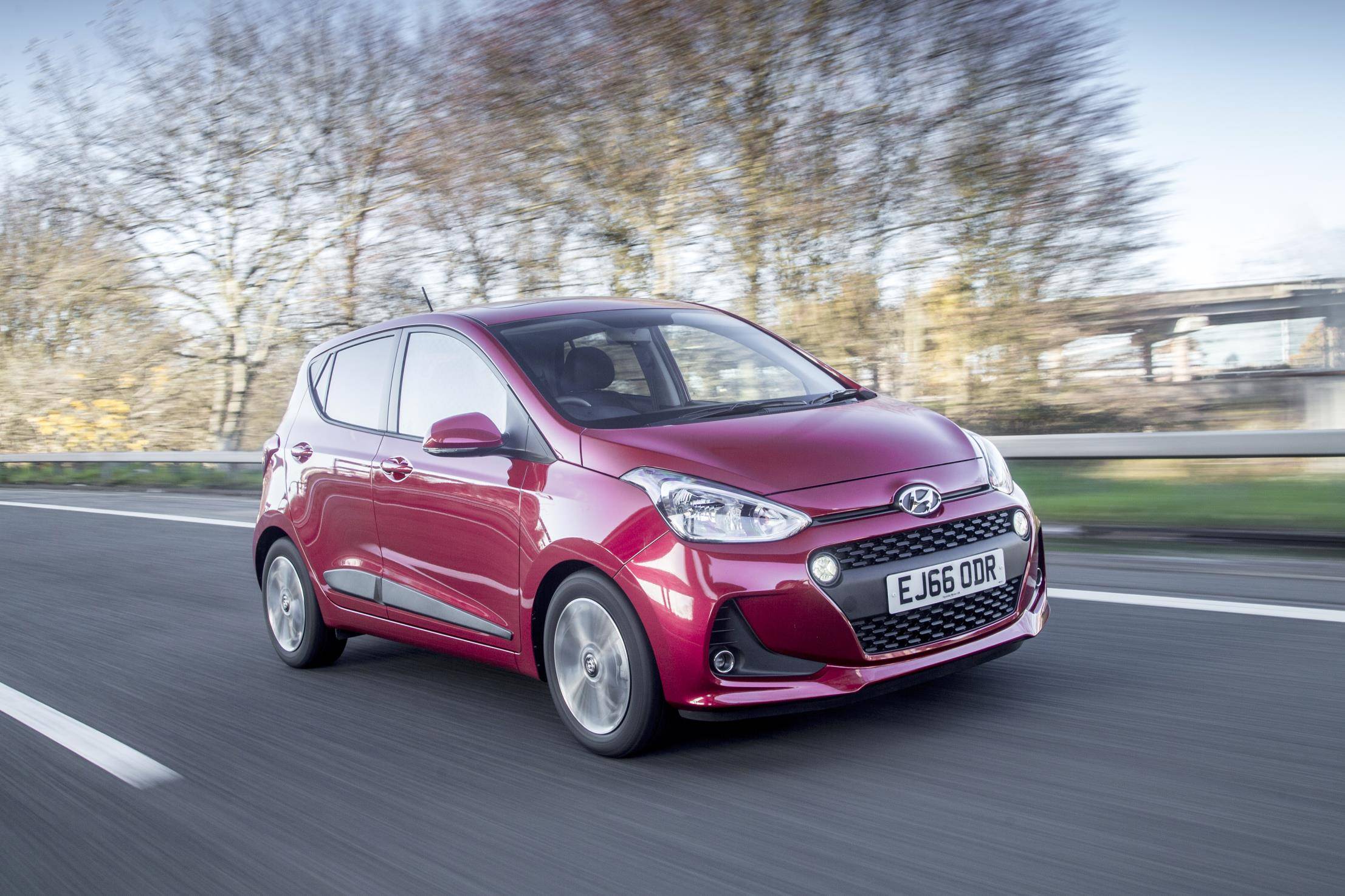 Red Automatic Hyundai driving down motorway 