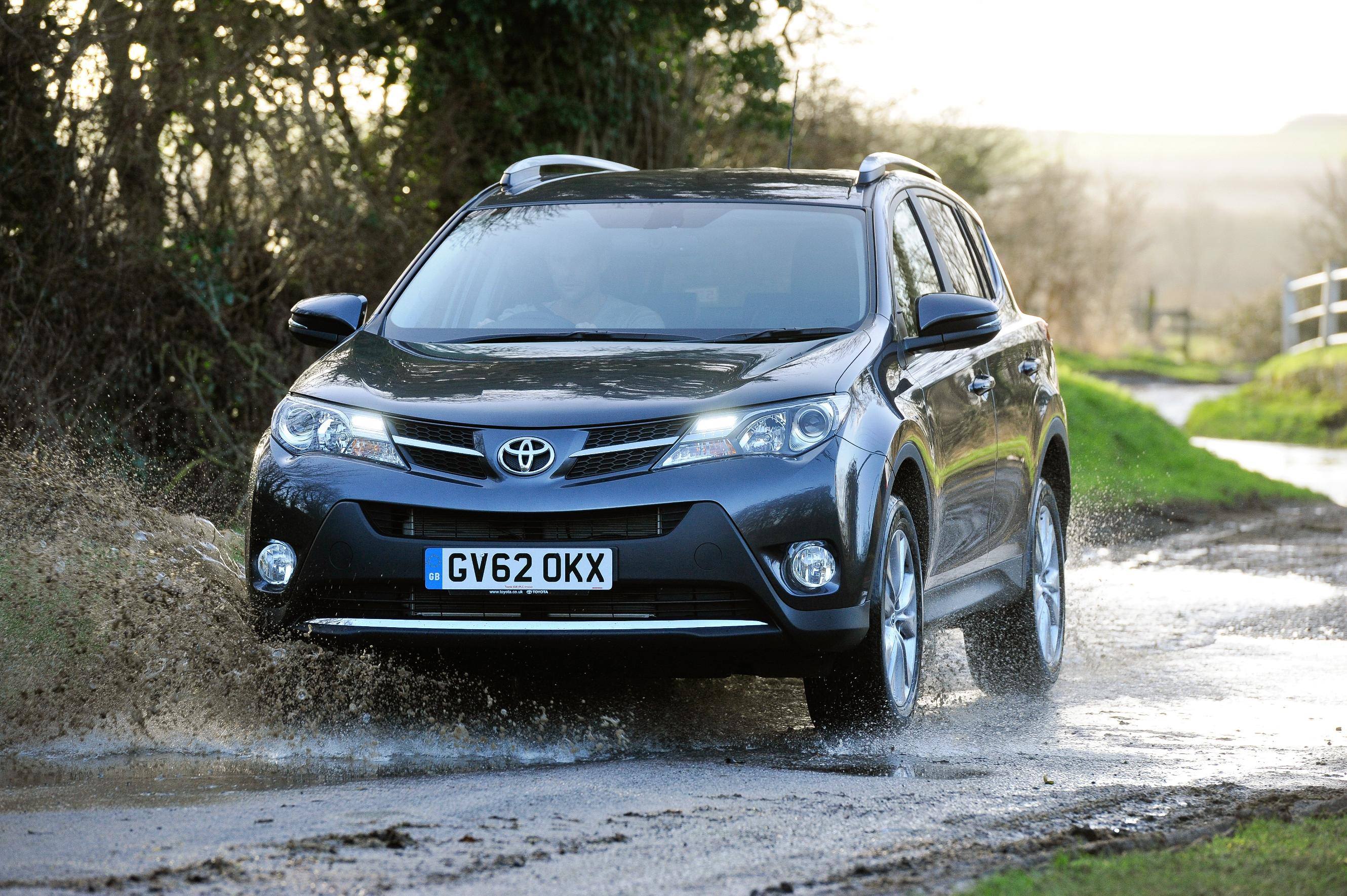 image of a black toyota rav4 car drivng through a puddle