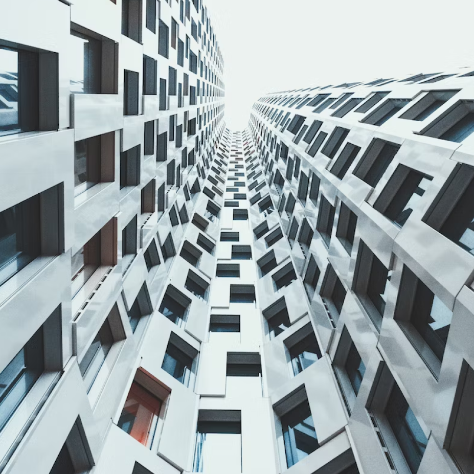 Looking up at a grey building with lots of square windows.