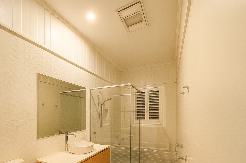 Exclusive Electrical & Air bathroom lighting installation featuring modern LED downlights above a shower and vanity, providing bright and efficient illumination.