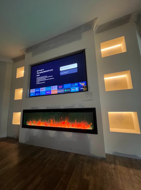 Exclusive Electrical & Air installation featuring a modern electric fireplace with custom LED-lit wall niches and mounted smart TV for a stylish living room upgrade.