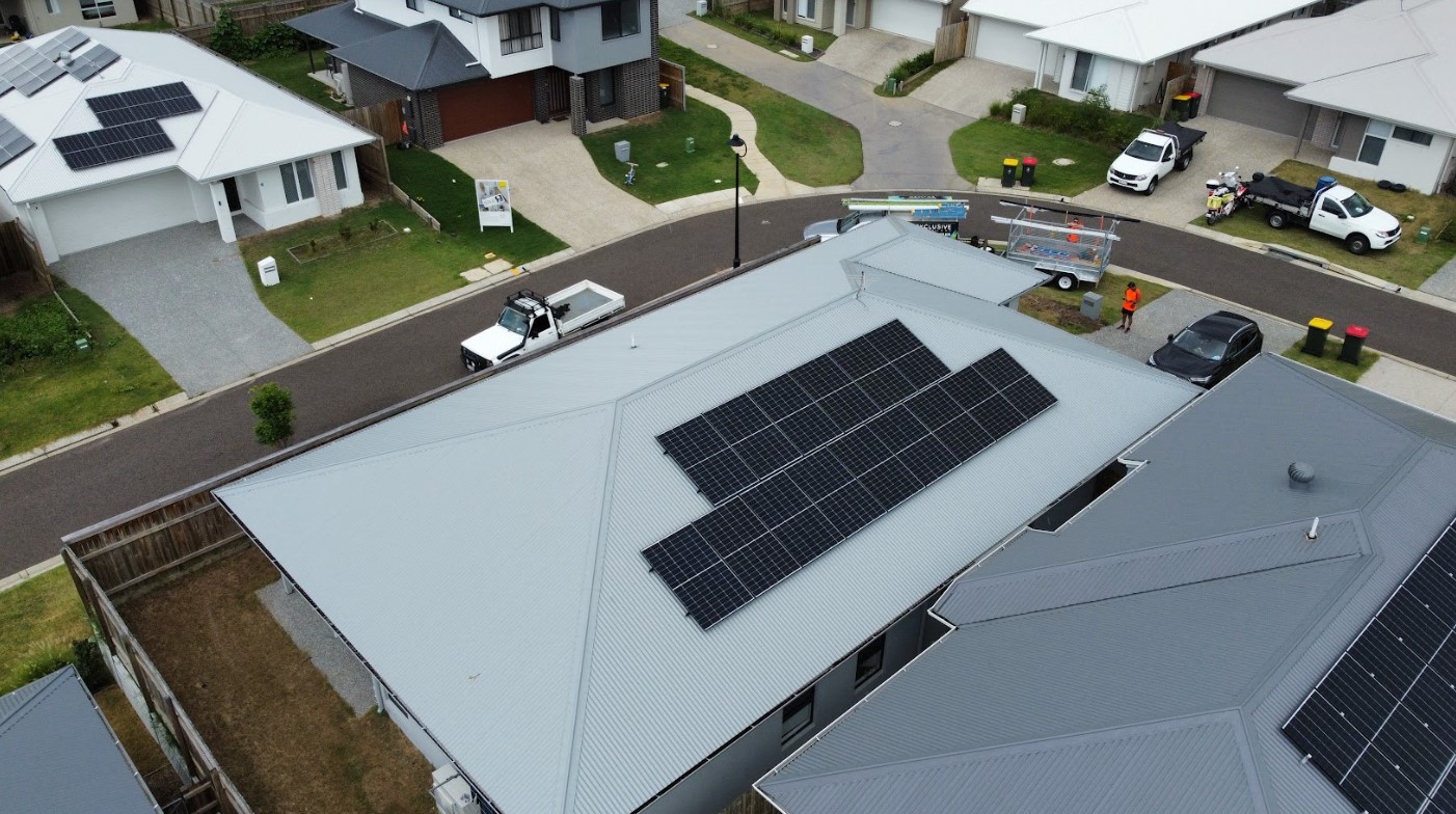 Aerial view of a newly built Brisbane home with rooftop solar panels installed by Exclusive Electrical & Air, providing clean and efficient renewable energy.