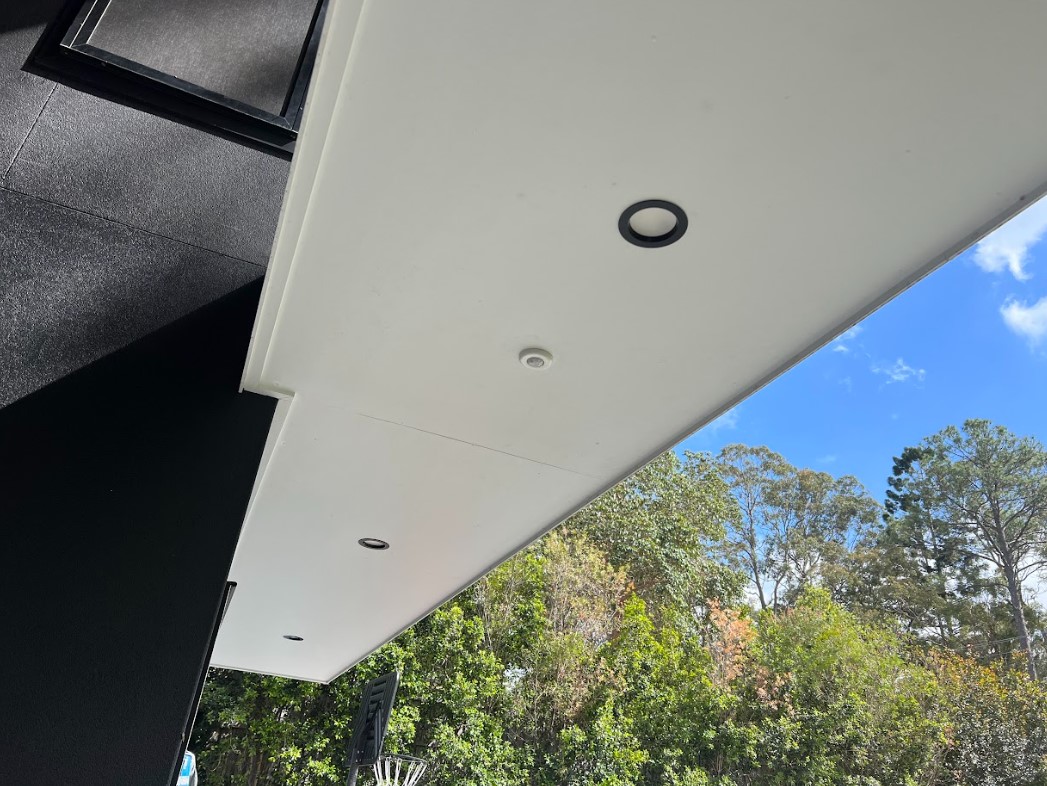 Outdoor ceiling with modern recessed downlights installed by Exclusive Electrical & Air, providing stylish and energy-efficient exterior lighting against a bright sky backdrop.