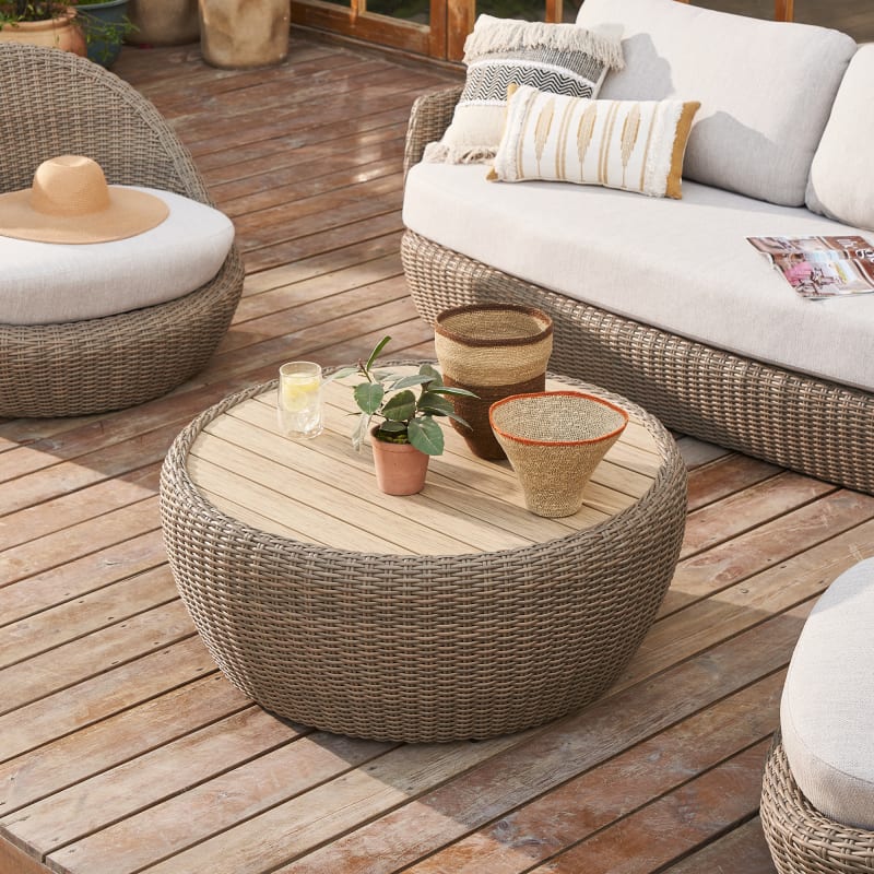 Two Small Coffee Tables And Wicker Chair With Pillow On It In