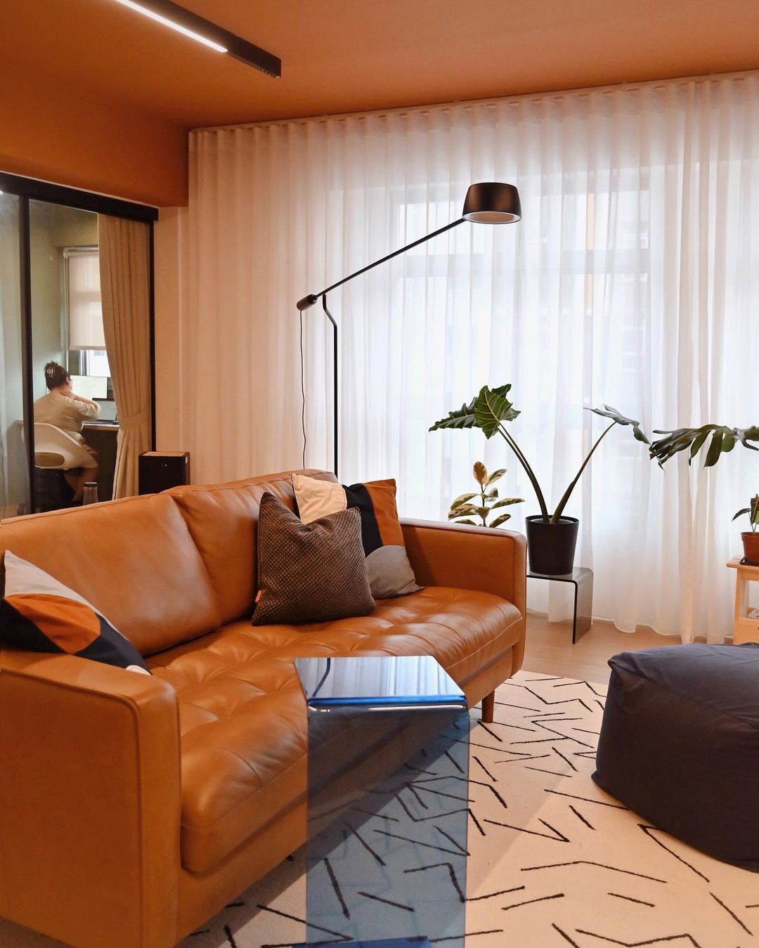 A leather sofa in a living room with a clear blue c-side table.