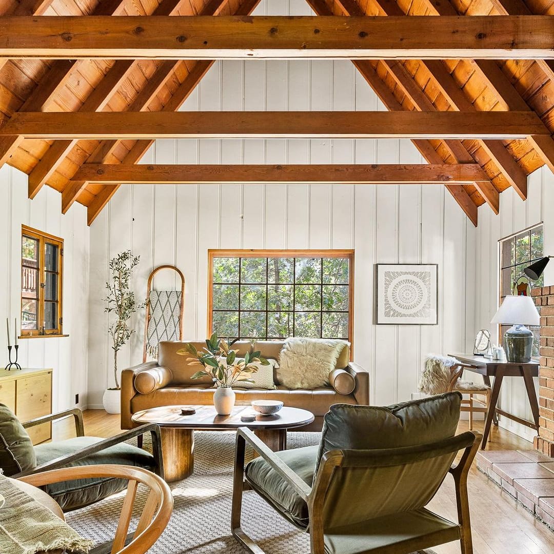 A living room with wooden beams on the ceiling.