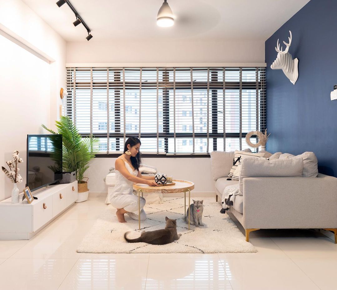 A person is arranging decor on a coffee table in the living room.