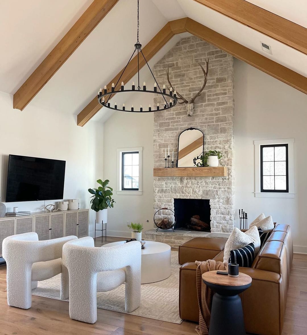 A large fireplace in a living room with a leather sofa, two armchairs, and a coffee table.