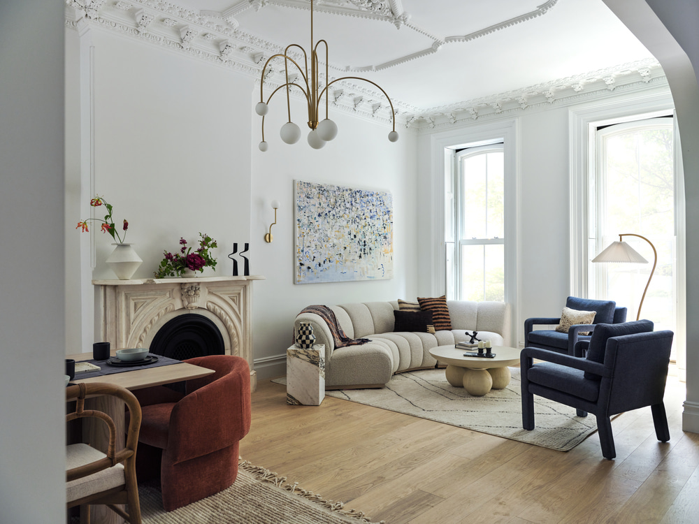 An open-layout living room with the living and dining area separated into distinct zones with large rugs.