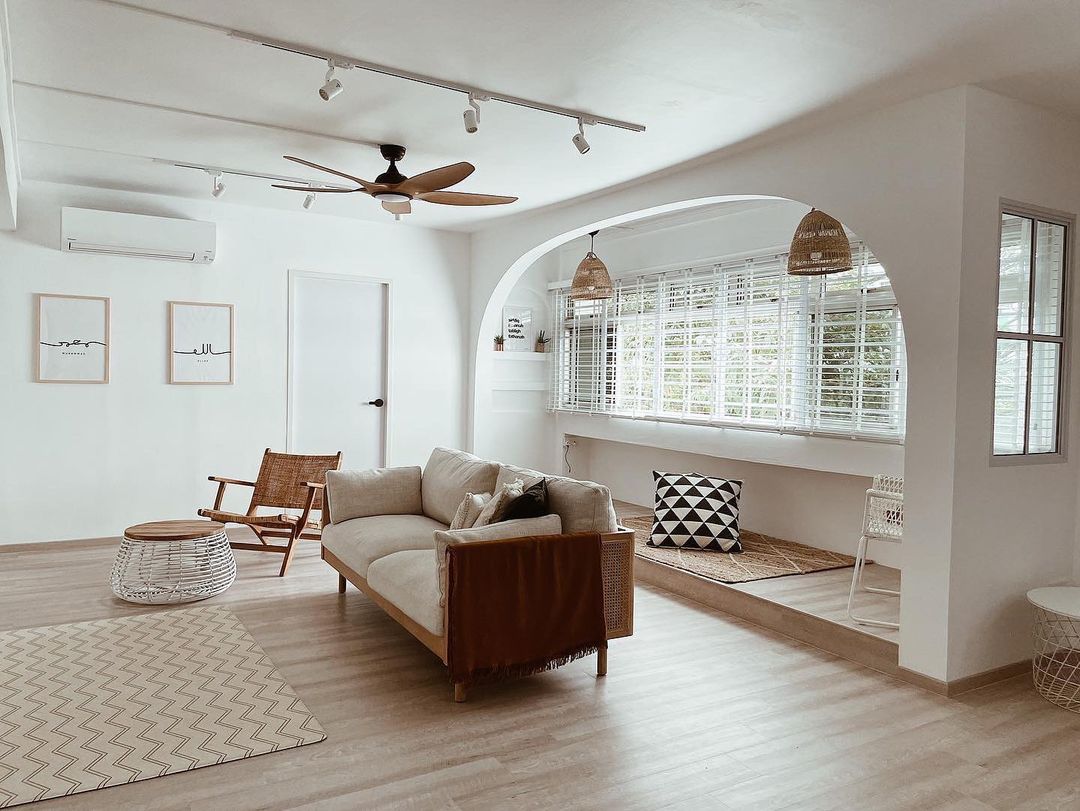 A cane sofa placed in the center of a living room alongside an armchair and a coffee table.