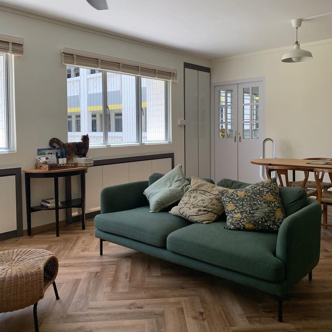 A green sofa placed in the center of a living room.