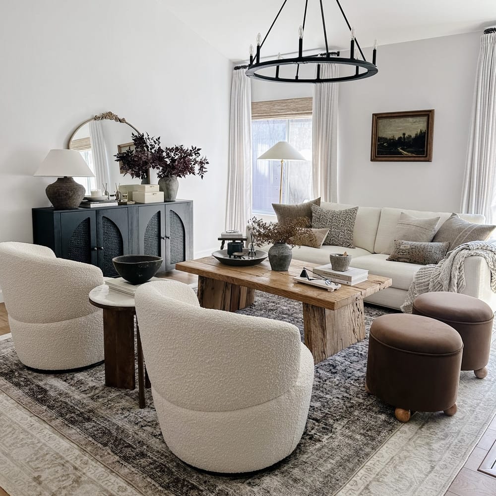 A sofa, two armchairs, and two stools form a u-shaped living room layout.