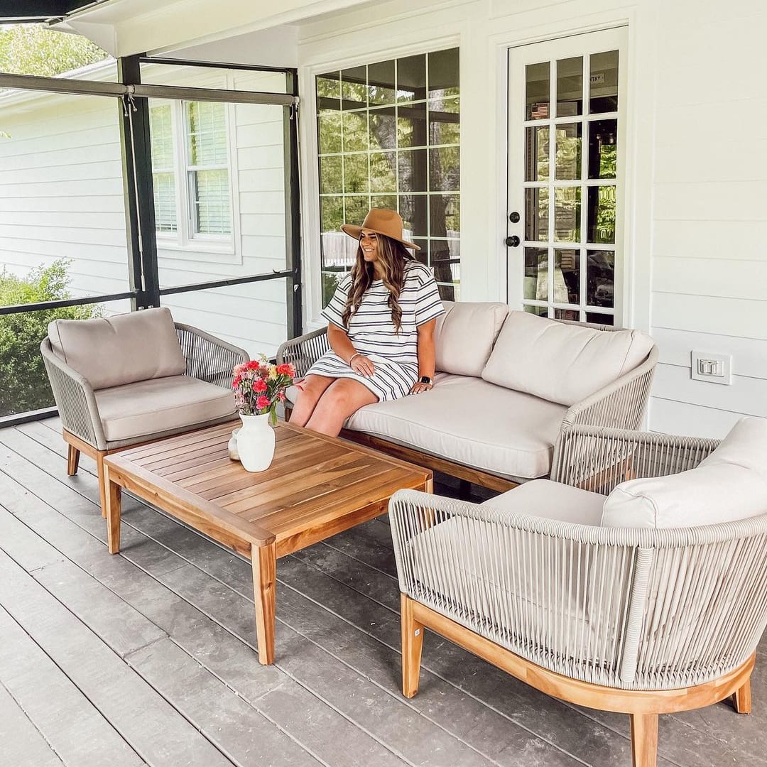 A person sitting on an outdoor loveseat on the deck.