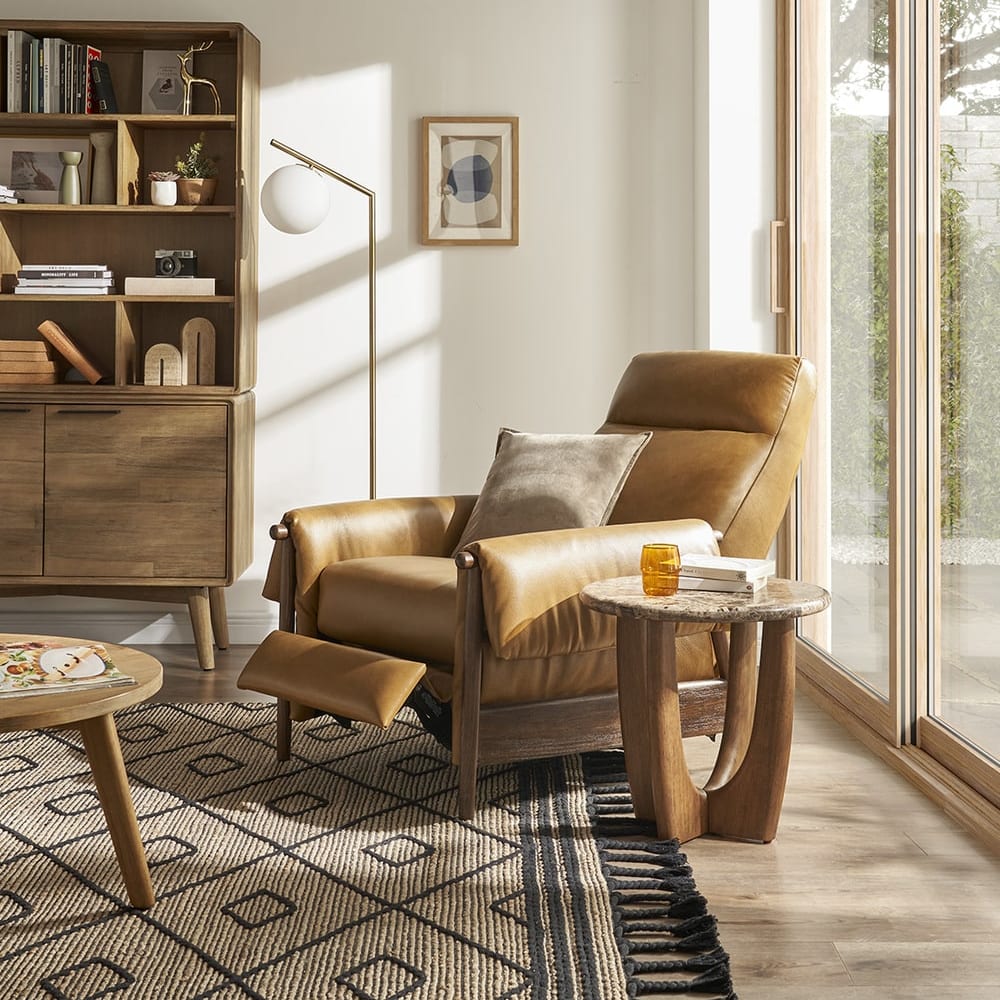 A leather recliner chair and a marble side table beside it.