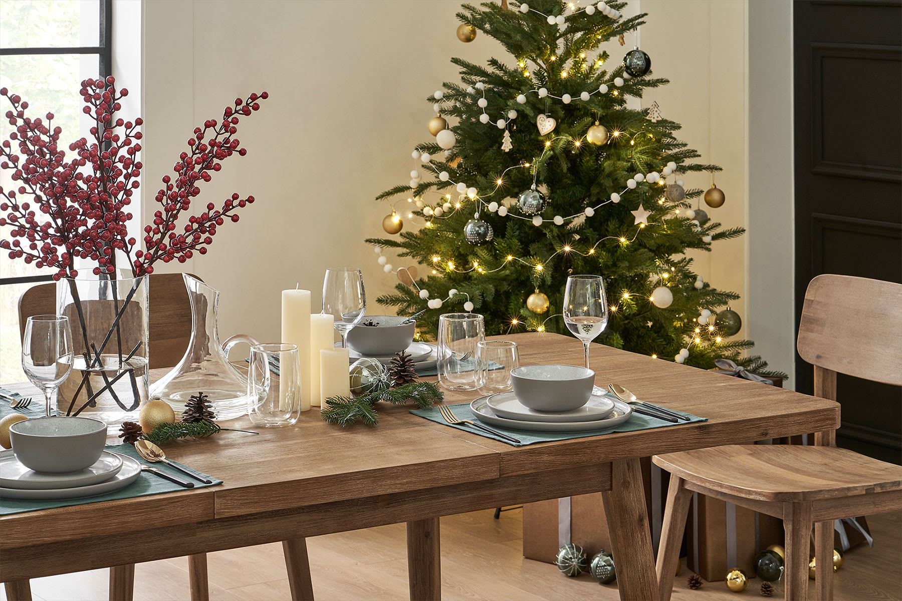 A Christmas tree in the corner of a dining room.