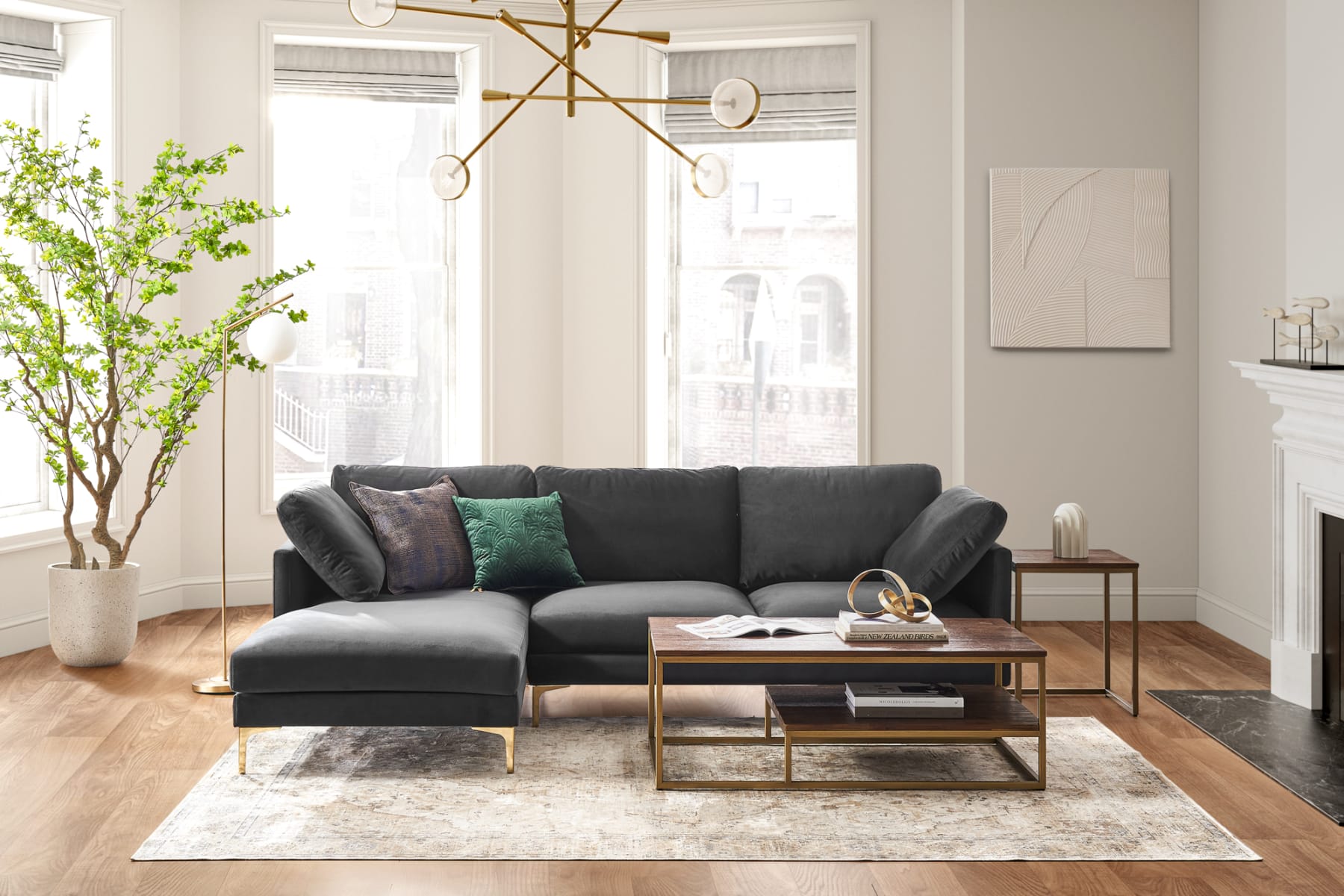 Modern black velvet sofa with brass legs in a living room