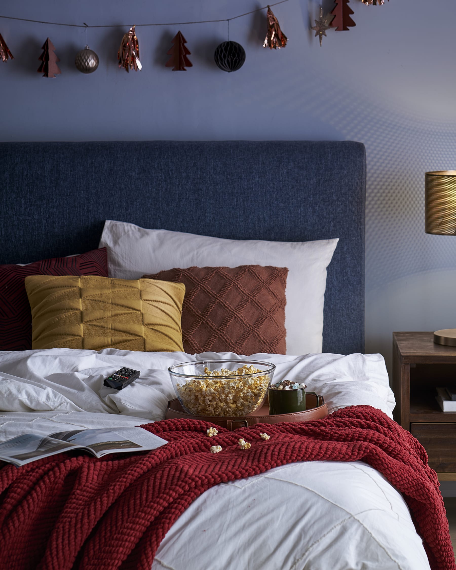 A bowl of popcorn on a bed.