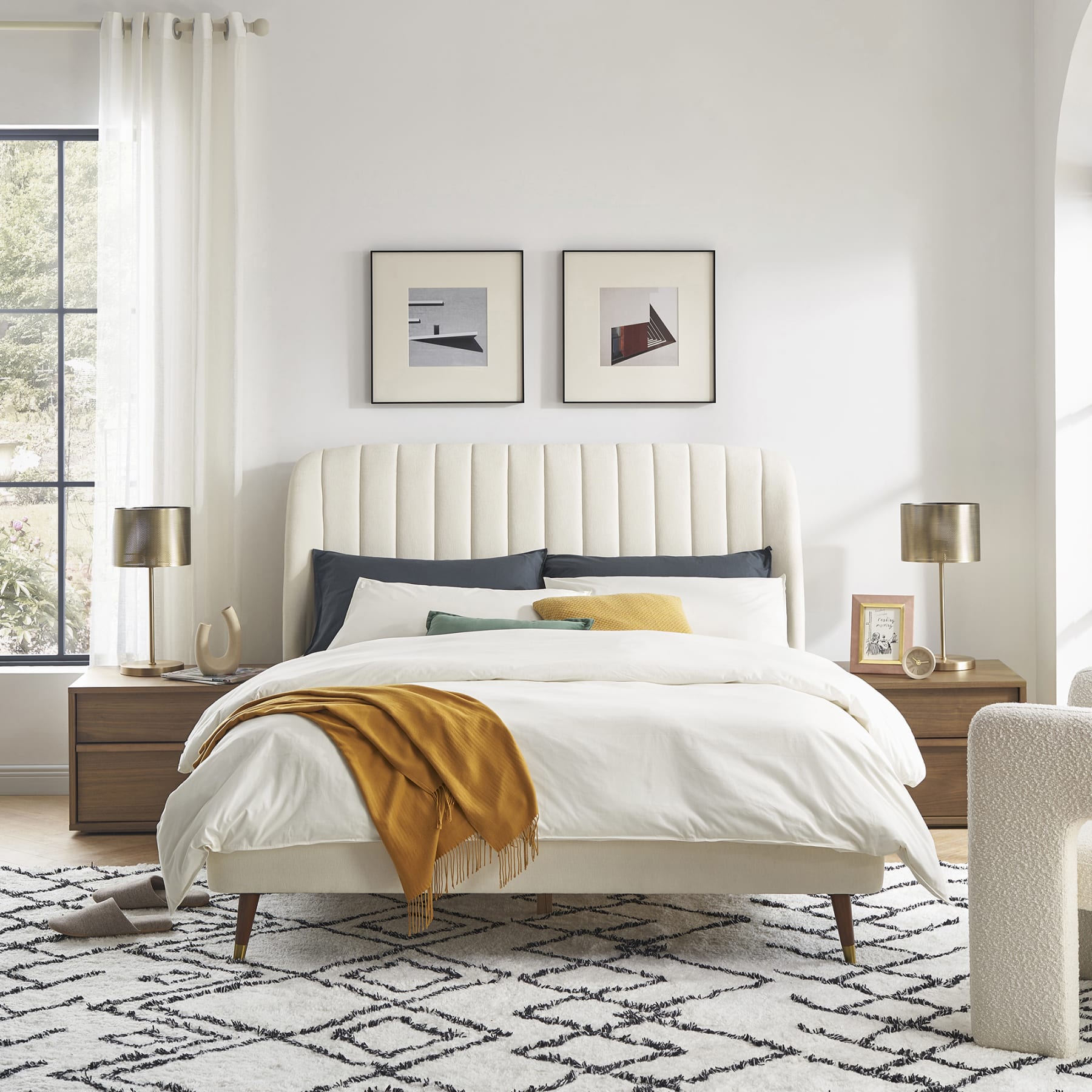 Modern bedroom styled with cosy white sheets and a patterned rug