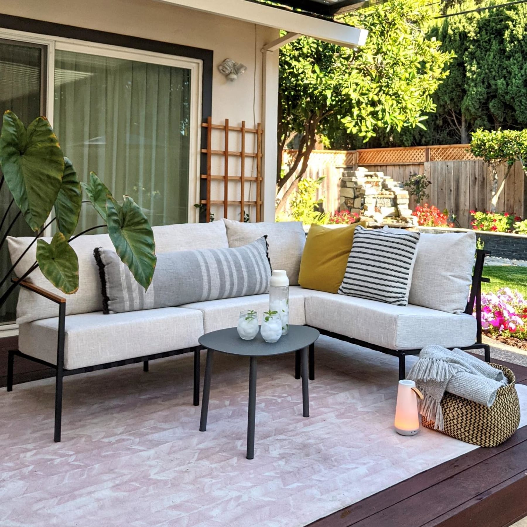 Minimalist outdoor sofa with steel legs positioned on a front porch