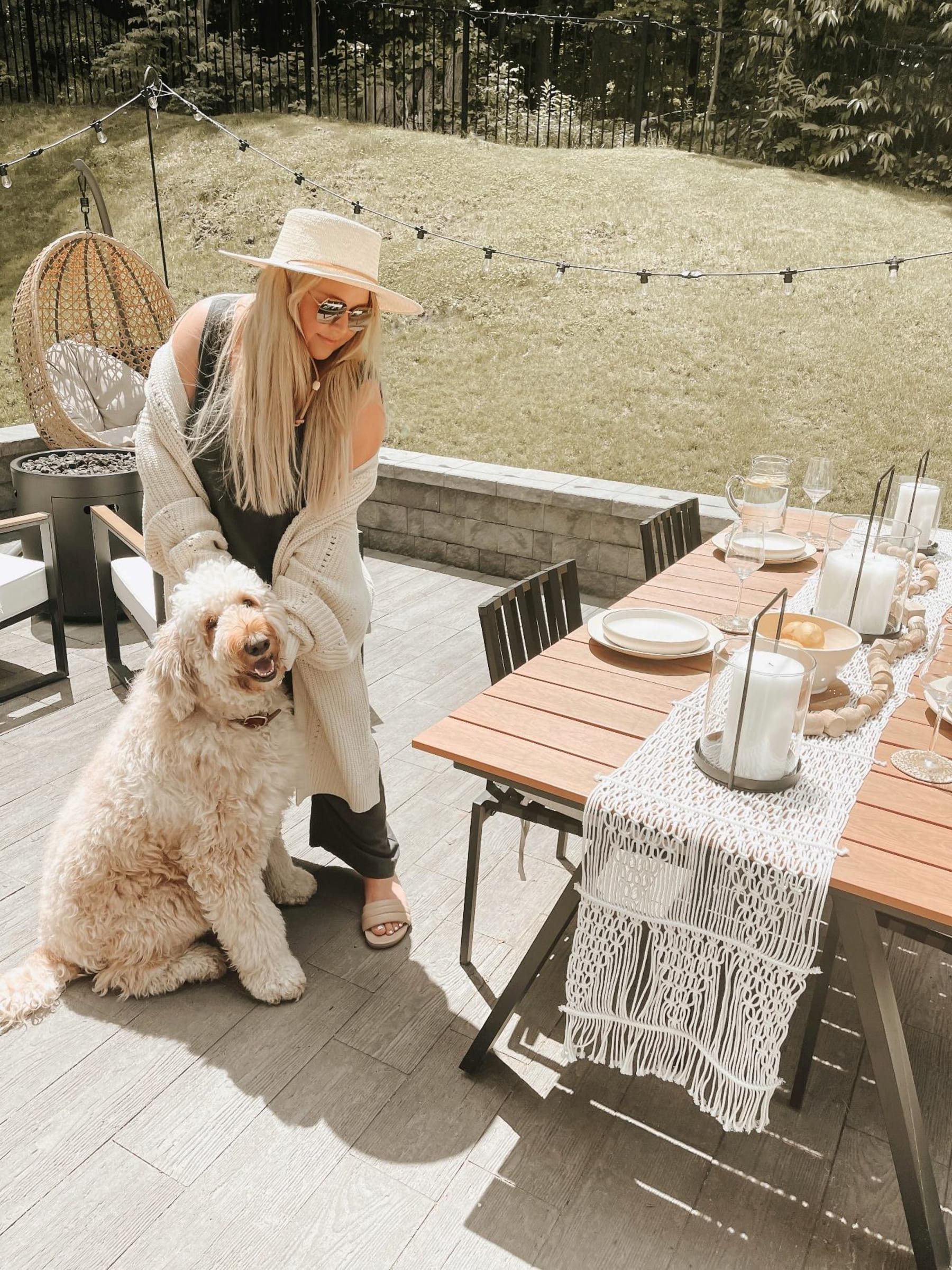 A girl and her dog in front of an outdoor dining table setting