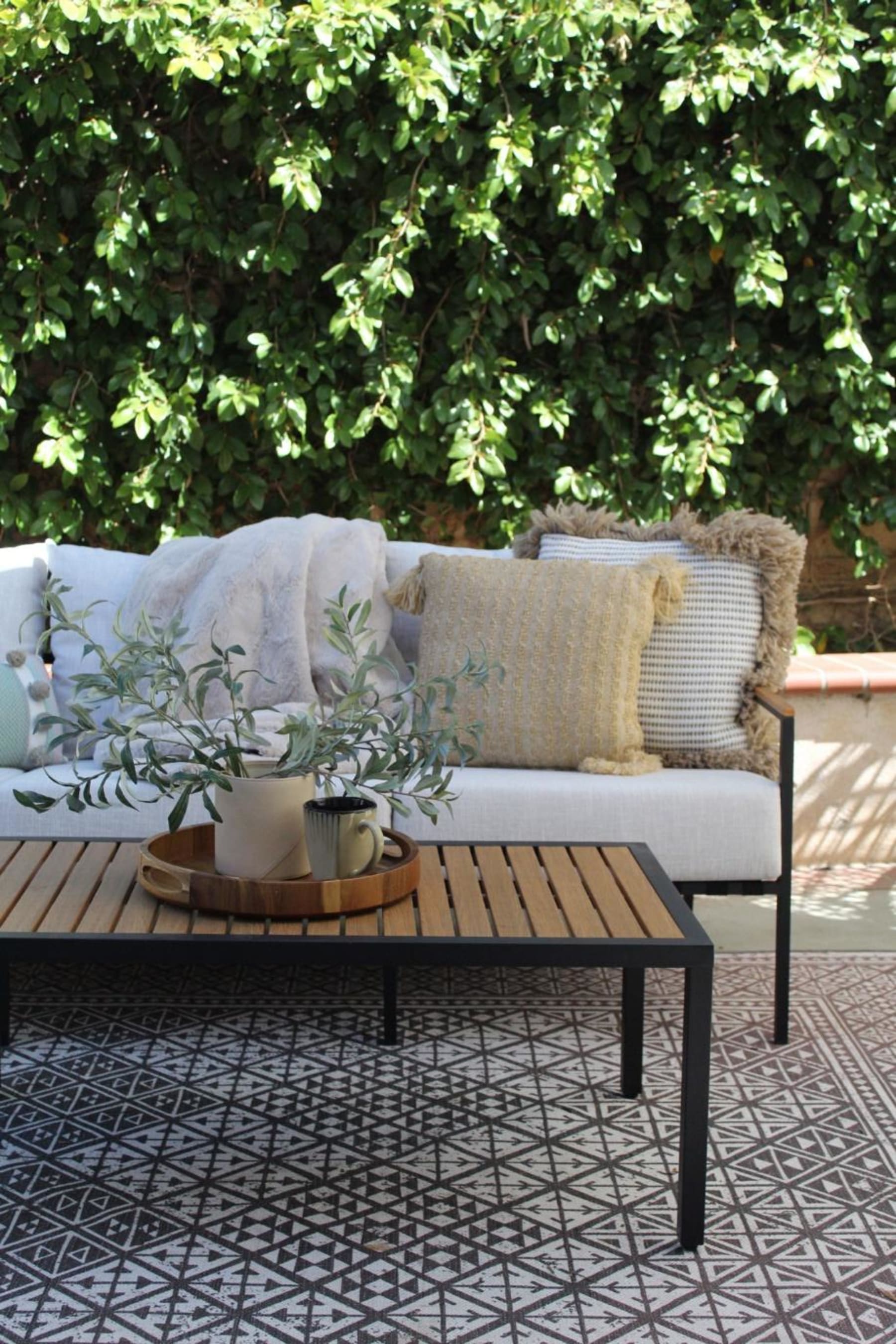 Outdoor lounge set styled with cosy cushions and throw