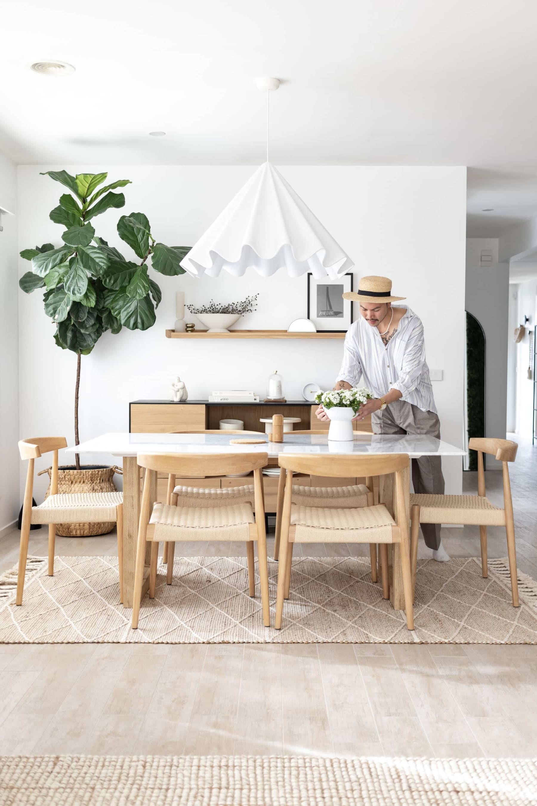 woven and cane dining chairs with white wash on a natural coloured jute rug with tassels